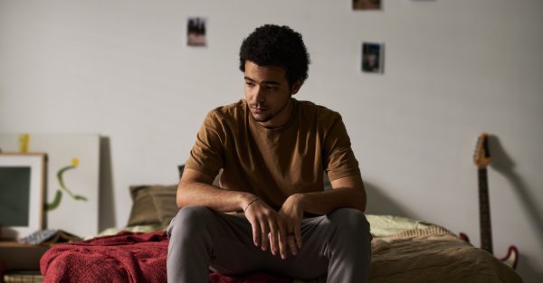 Mladić sjedi sam u sobi uz prozor, simbol izolacije i hikikomori sindroma