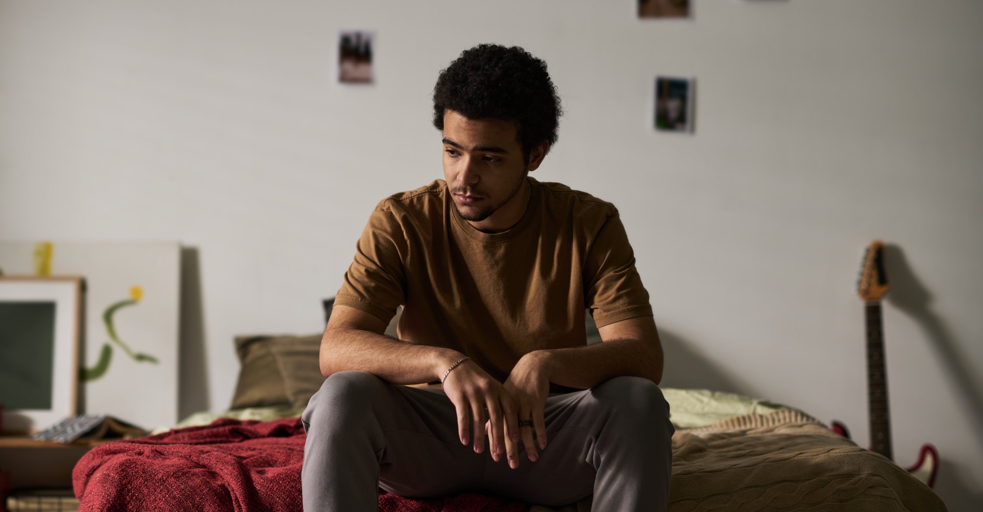 Mladić sjedi sam u sobi uz prozor, simbol izolacije i hikikomori sindroma