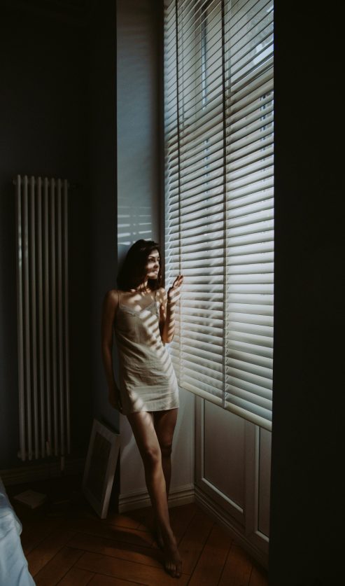 žena stoji uz prozor i gleda van osjećaj unutarnjeg nemira i tišine