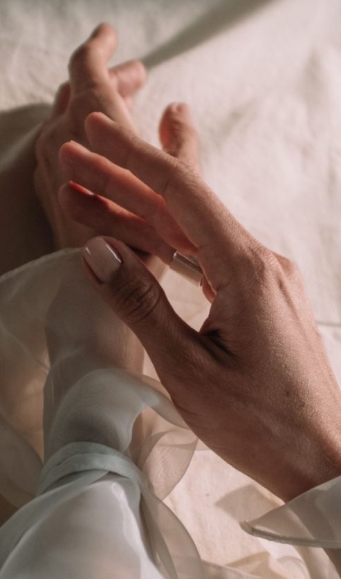 Ženska ruka s prirodnom nude manikurom u nježnoj ružičastoj nijansi, trendom koji obilježava ljeto 2026.