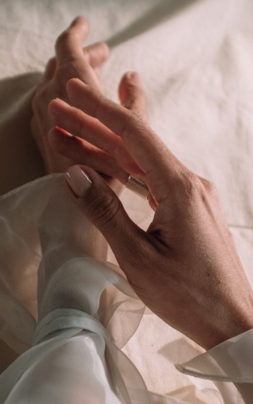 Ženska ruka s prirodnom nude manikurom u nježnoj ružičastoj nijansi, trendom koji obilježava ljeto 2026.