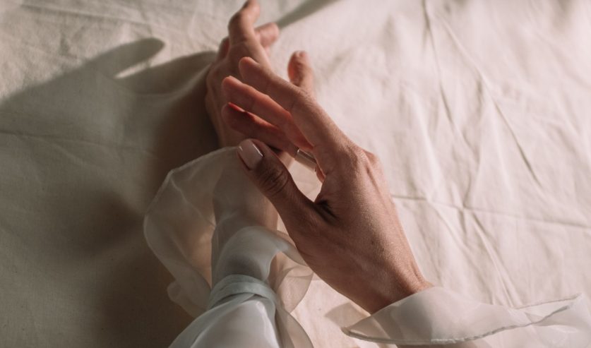 Ženska ruka s prirodnom nude manikurom u nježnoj ružičastoj nijansi, trendom koji obilježava ljeto 2026.