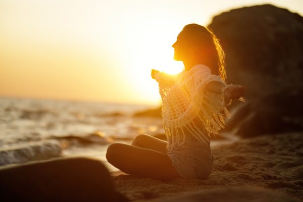 Žena na plaži u zlatnom svjetlu zalaska Sunca kao simbol energije Jupitera kazimija i novih životnih
