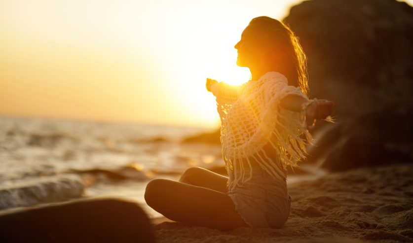 Žena na plaži u zlatnom svjetlu zalaska Sunca kao simbol energije Jupitera kazimija i novih životnih