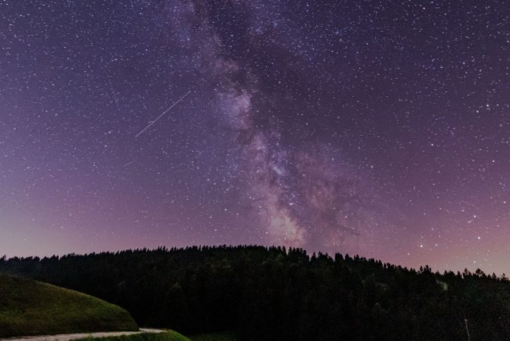 Perzeidi na noćnom nebu iznad planinskog krajolika tijekom vedre kolovoške noći.